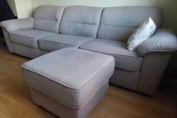 Mooi beige 4-zitsbank met als extra een bijbehorende poef beschikbaar voor biedingen