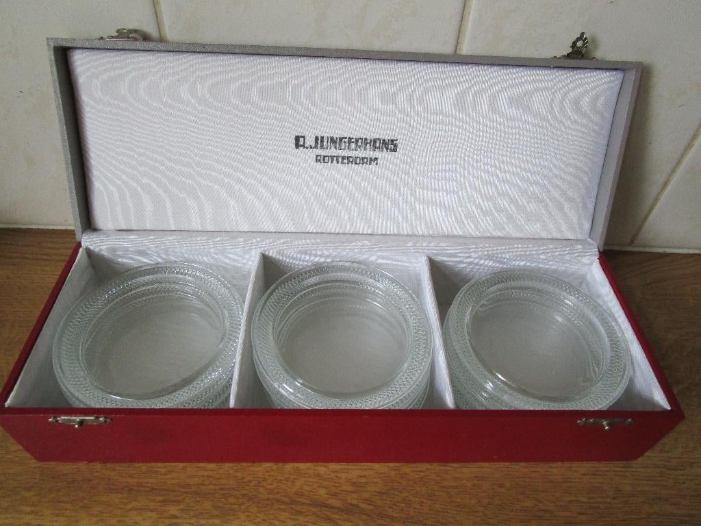 12 glazen onderzetters in kistje Jungerhans R'dam. Vintage, Ophalen of Verzenden, Gebruikt, Glas of Kopje