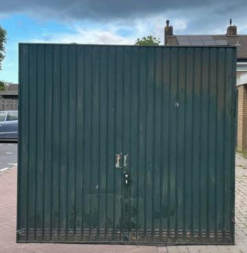 Oude garagedeur met schade. beschikbaar voor biedingen