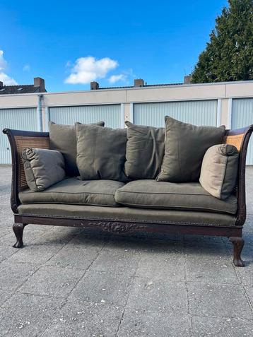 Rieten bank met goede kussens beschikbaar voor biedingen