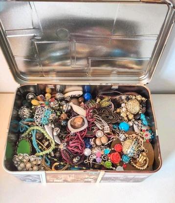 Blik vol met sloopsieraden en restanten hobby materialen beschikbaar voor biedingen