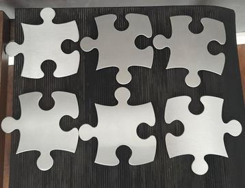 Bijzonder set van 6 design RVS onderzetters i puzzelstukvorm beschikbaar voor biedingen