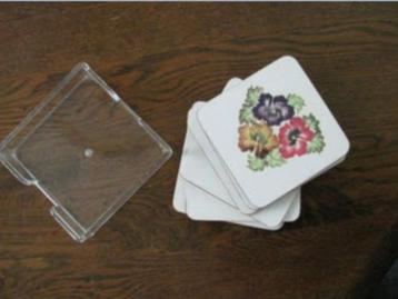 leuke onderzetters in kunststof houder beschikbaar voor biedingen