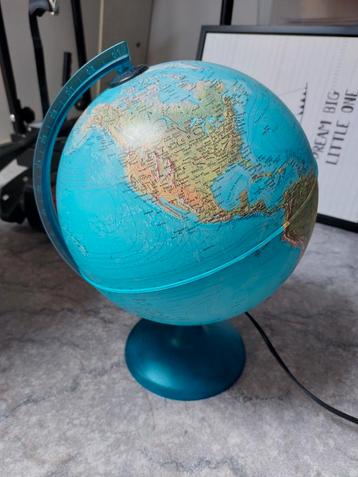 Wereldbol met lamp op blauwe voet