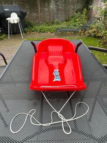 Rode slee met trekkoord beschikbaar voor biedingen