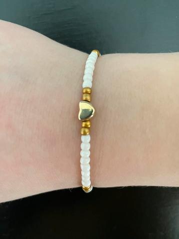 Armband met wit, goud en een goud hartje. beschikbaar voor biedingen
