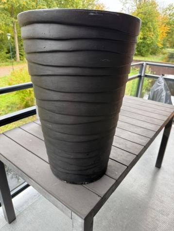 Hoge matzwarte bloemenpot beschikbaar voor biedingen