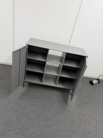 Grijze metalen kast met deuren en planken beschikbaar voor biedingen