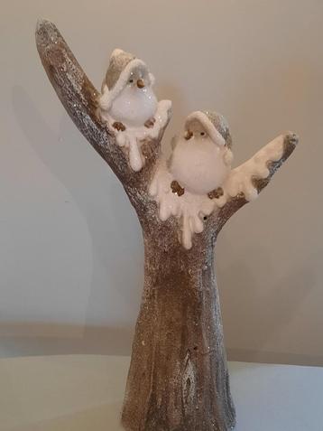 Stenen boomstam met 2 vogels in de sneeuw beschikbaar voor biedingen