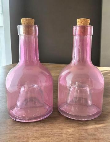 2 roze glazen flessen met hoge concave bodem. beschikbaar voor biedingen