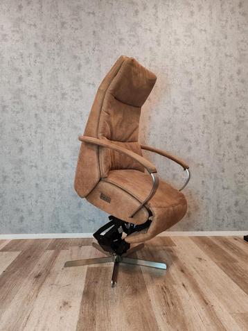 Prominent Humberto Tan sta op stoel relax fauteuil op accu beschikbaar voor biedingen