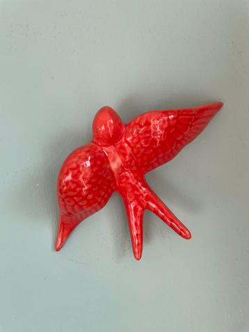 Roze rode keramieken zwaluw beschikbaar voor biedingen