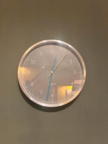 Zilverkleurige Wandklok met Blauwe Accenten beschikbaar voor biedingen
