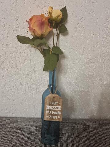 Blauw vaasje met bloemen en decoratie beschikbaar voor biedingen