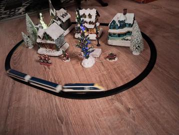 Kerstdorp met rijdende trein en verlichte bomen. beschikbaar voor biedingen