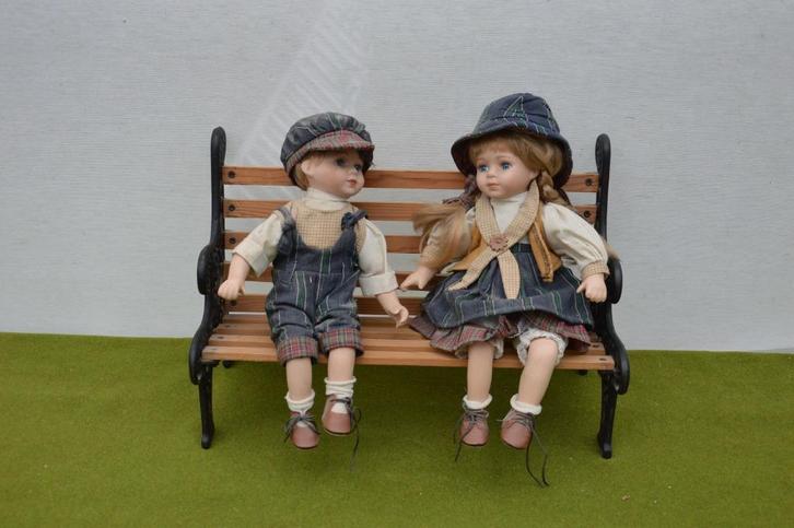 2 Vintage porseleinen poppen op een gietijzeren bankje 39 cm, Antiek en Kunst, Curiosa en Brocante, Ophalen of Verzenden