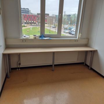 Lange smalle tafel met grijze stalen poten - in hoogte vers beschikbaar voor biedingen