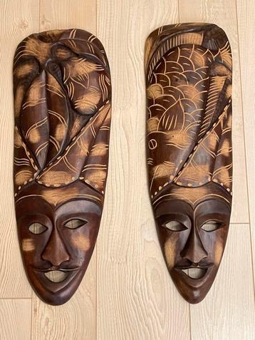 Twee handgesneden houten maskers beschikbaar voor biedingen