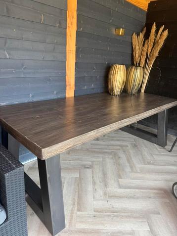 Houten tafel met stalen poten beschikbaar voor biedingen