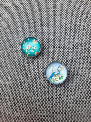 2 pins met plaatjes van bloemen met een vogeltje te koop beschikbaar voor biedingen