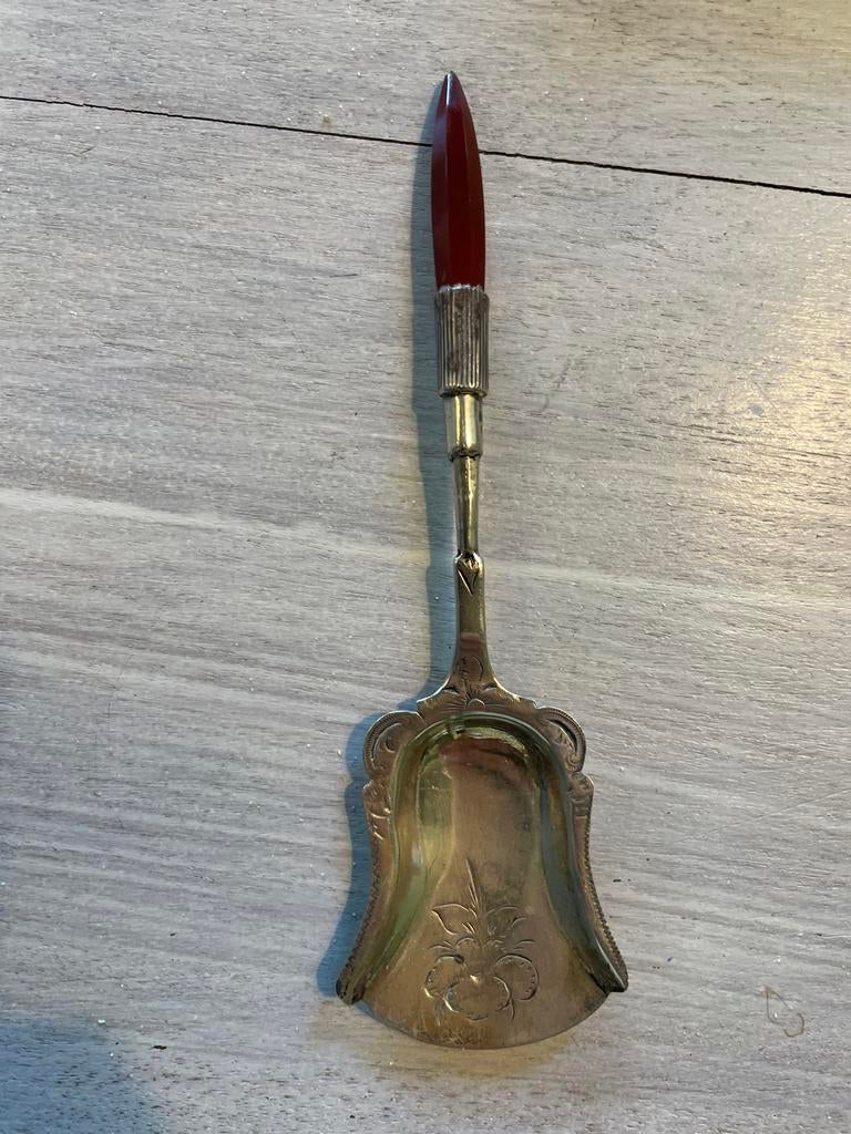 Antieke zilveren suikerschep met rood handvat, Ophalen
