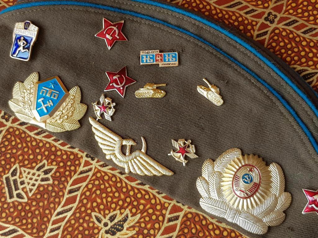 Oude militaria pet uit Rusland met speldjes en badges., Antiek en Kunst, Ophalen of Verzenden