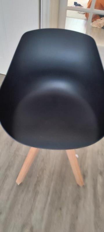 Zwarte design stoel met houten poten beschikbaar voor biedingen