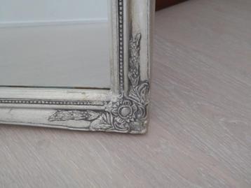 Spiegel met zilverkleurige lijst met bloemdetails beschikbaar voor biedingen