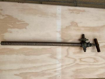 Oude messing pomp met houten handvat beschikbaar voor biedingen