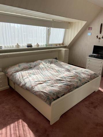 Wit bed met achterwant en nachtkastjes, kaptafel met spiegel
