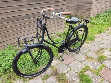 Zwarte transportfiets met voorrek beschikbaar voor biedingen
