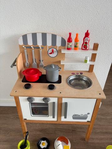 Speelkeukentje met speelgoed eten en servies beschikbaar voor biedingen