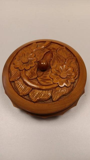 Rond houten bakje met deksel besneden in bloemmotief.
