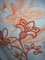 Mooie lap tricotstof met een geborduurde orchidee., Hobby en Vrije tijd, Stoffen en Lappen, Ophalen of Verzenden, Nieuw, Blauw