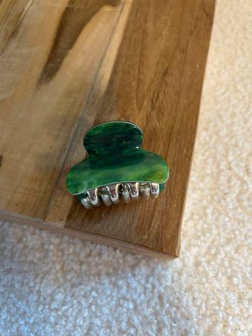 Groen klein haarklemmetje beschikbaar voor biedingen