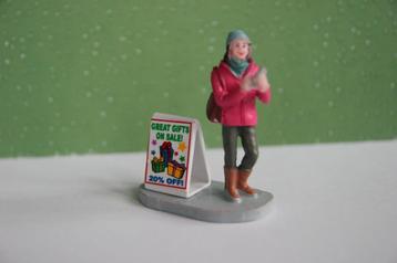 Lemax figurine voor in een kerstdorp. Vrouw met bord beschikbaar voor biedingen
