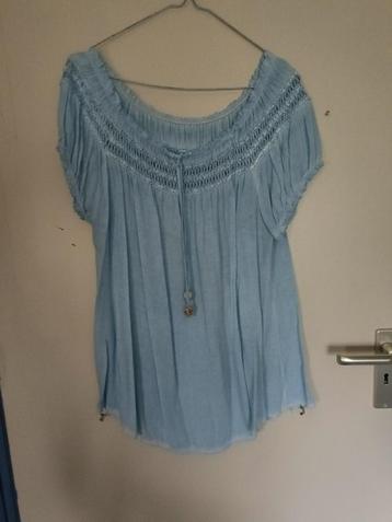 Een licht - blauwe tuniek met sierrand aan de bovenkant. beschikbaar voor biedingen