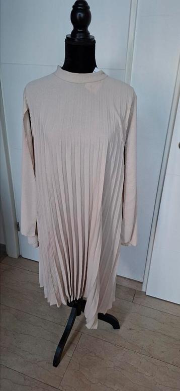 95)Te koop nieuw beige plooi jurk 1maat ongv.48/50 beschikbaar voor biedingen