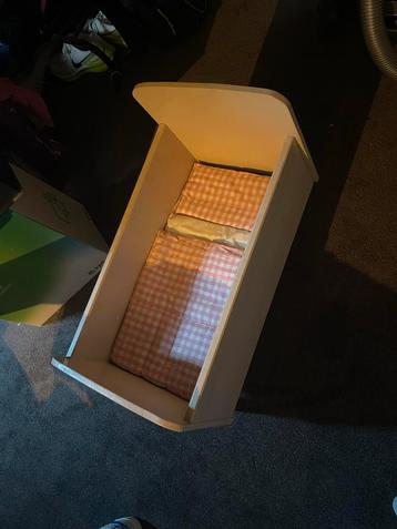 Poppenwiegje met roze dekentje beschikbaar voor biedingen