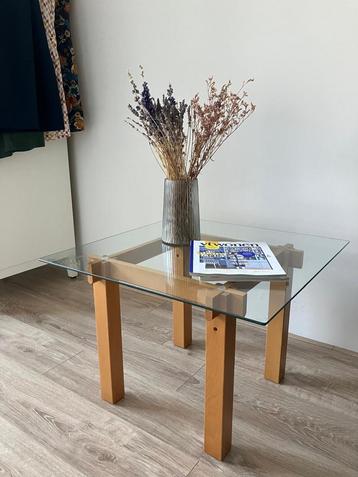 Glazen salontafel met houten poten beschikbaar voor biedingen