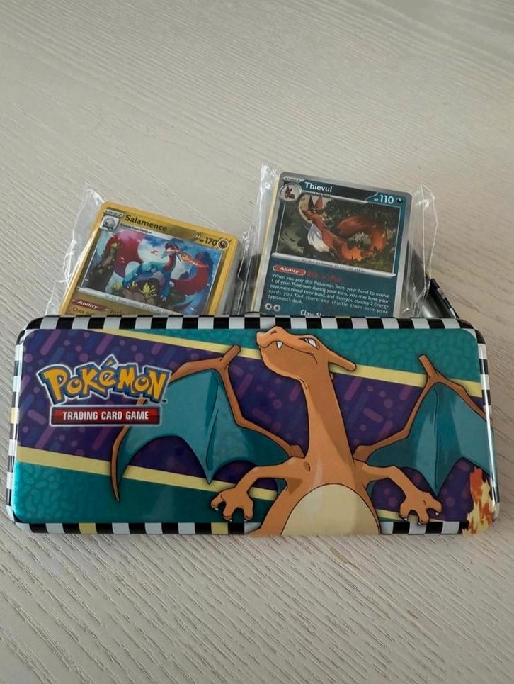 Charizard Pokemon Tin met 100 kaarten + 8 glimmende, Hobby en Vrije tijd, Verzamelkaartspellen | Pokémon, Zo goed als nieuw, Meerdere kaarten