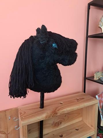 Mooi zwarte hobbyhorse met lange manen en blauwe ogen