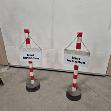 2x rood/witte metalen palen met betonvoet  beschikbaar voor biedingen