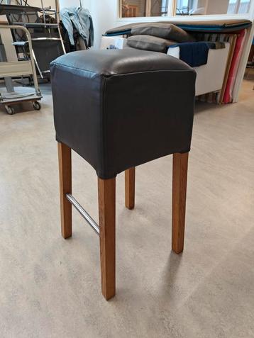 Donkerbruine leren kruk met houten poten beschikbaar voor biedingen