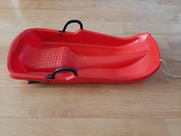 Rode plastic slee met remmen en trekkoord beschikbaar voor biedingen