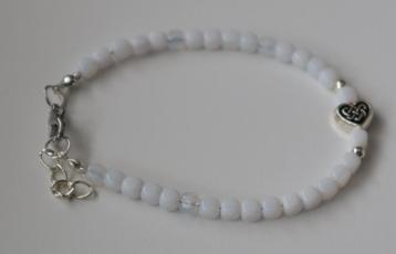 Armband met leuke witte kubuskraaltjes en een hartje beschikbaar voor biedingen