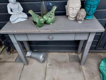 Grijze houten tafel met lade beschikbaar voor biedingen