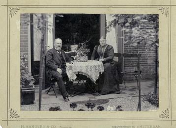 Portret van echtpaar voor huis zittend ca 1910