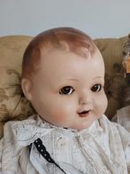 Antieke babypop met glazen ogen
