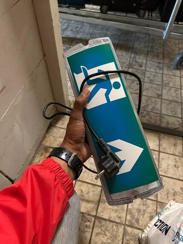 Nooduitgang bord met stekker beschikbaar voor biedingen